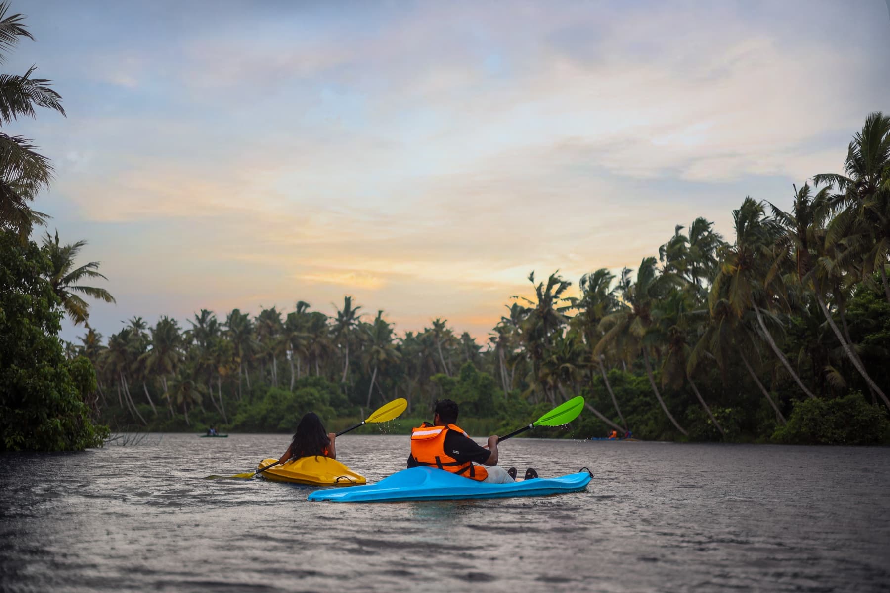 Two guests kayaking on the river at dusk